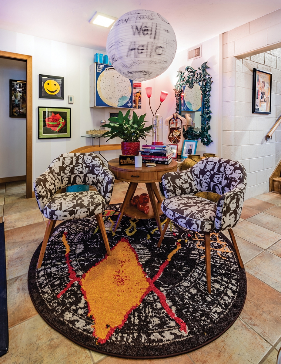A paper globe gets the Artus treatment: the morning of her home’s photo shoot, the artist decided this space in the living room/common area needed more. A paper globe now adorned with hand-lettered greetings swings merrily from the ceiling, mimicking the round shape of the rug below, the table and the two chairs – which are upholstered in celebrity faces, naturally.