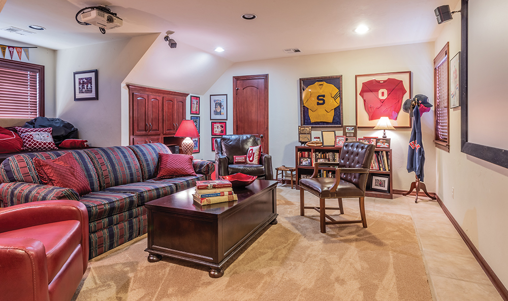 Upstairs, the Pryors retreat from the stresses of the day in this cozy, memorabilia-filled hideout. There is a nine-foot projection television on the wall, a well-stocked fridge and plenty of spots to settle in, including a roomy, pillow-filed window seat beloved by grandchildren and Lisa alike. Both Pryors are Sooner born and Sooner bred, and their collection of football, baseball and hockey ephemera covers nearly every available surface. Letter sweaters belonging to Lisa’s father Cecil Morris, co-captain of OU’s 1955 national champion team, hangs next to Dick’s grandfather’s letter sweater. The senior Dick Pryor attended Southeastern Oklahoma State University in the 1920s.