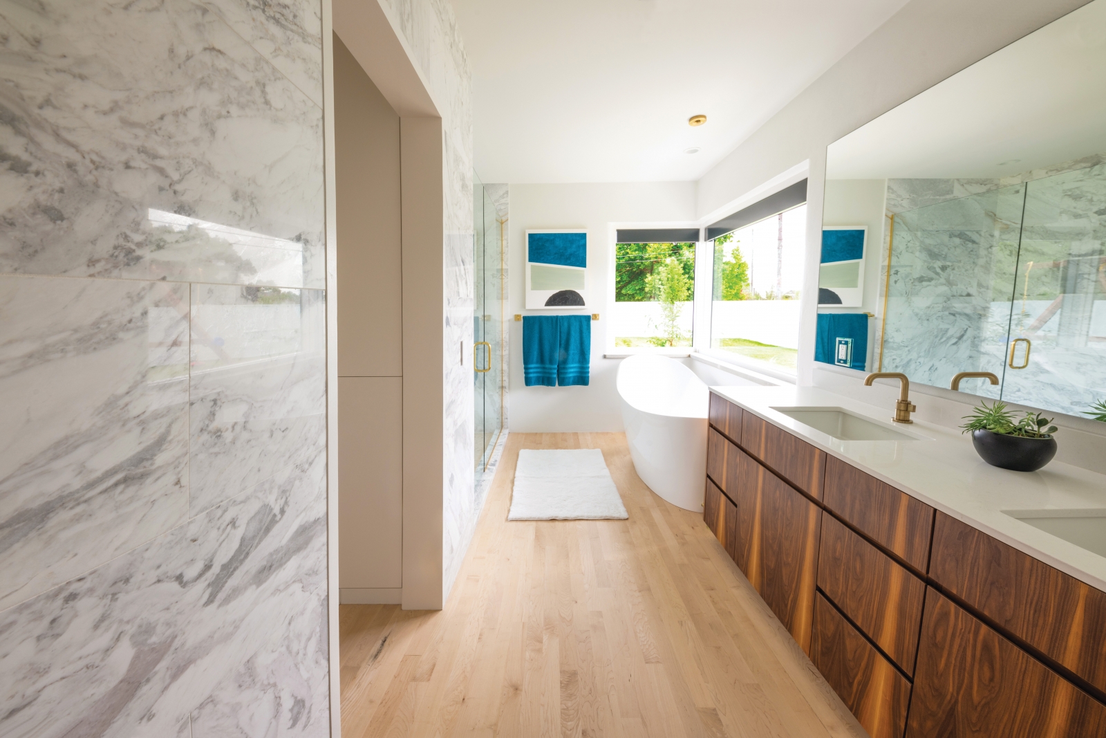 Natural elements are in charge in the master bath. Marble walls, minimally treated wood floors and beautifully grained cabinetry pair well with brass fittings. The soaking tub is filled by activating a spigot on the ceiling, which adds a little wit and drama to an ordinarily mundane task.