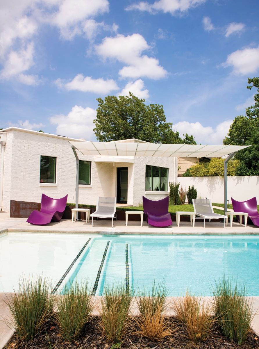 Minimal pops of contrasting colors in the form of purple lounges, emerald green grass, cool blue water and bright skies add a dash of cool to the home’s white façade.