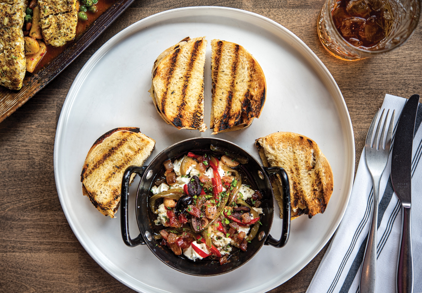 Olives, peppers, garlic and bacon elevate the baked chevre.