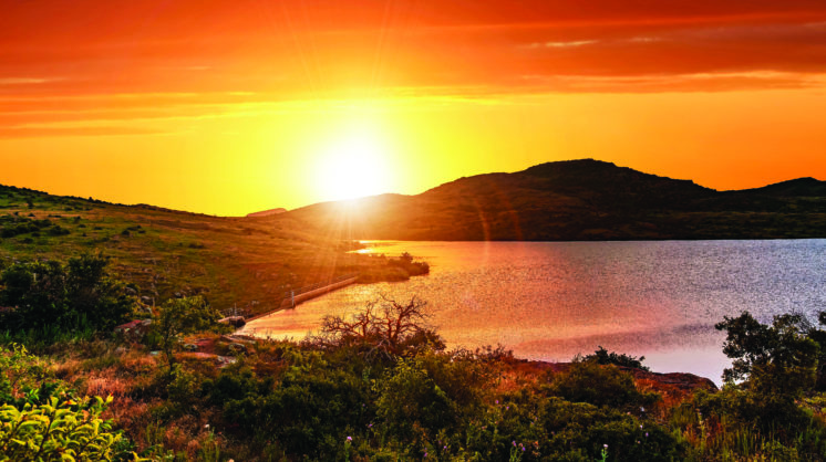 A Bright Orange Crimson Sunset In The Valley Of Wichita Mountain