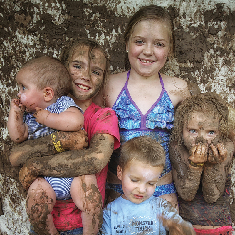 The Myriad Gardens sold out its June 29 International Mud Day celebration, encouraging kids to roll in the mud, make mud pies, create pinch pots and build mud fairy houses. Taking a break before getting hosed off: Sakari Wilkinson, 9, (center) and siblings Lauryn Crawford, 5 months, Jocelyn Crawford, 6, Logan Crawford, 3, and Kailyn Crawford, 9, all of south Oklahoma City.