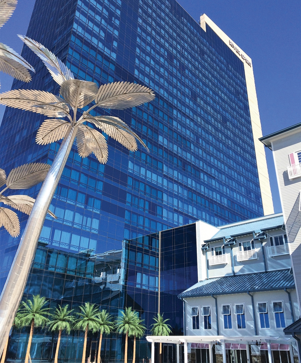 The 27-story River Spirit hotel tower dwarfs palm trees on the pool deck.