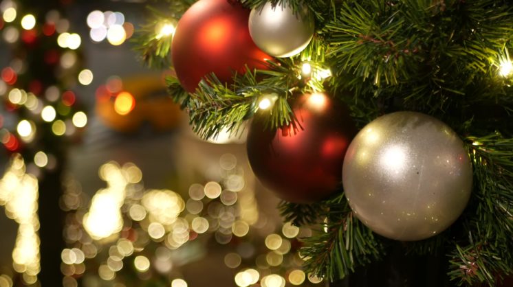 Closeup,of,festively,decorated,outdoor,christmas,tree,with,bright,red