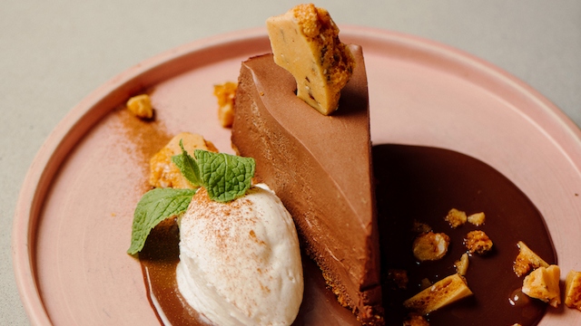 The Mexican hot chocolate cheesecake at Frida's Southwest. The slice of chocolate sits in a pool of melted chocolate.