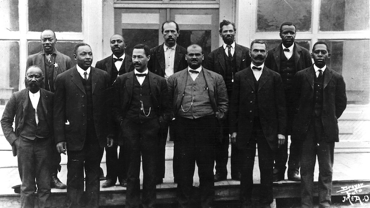 An historical photo of the town council of Boley, Oklahoma, posing in front of the town hall. Boley is currently the largest of the still existing historical All-Black towns in Oklahoma.