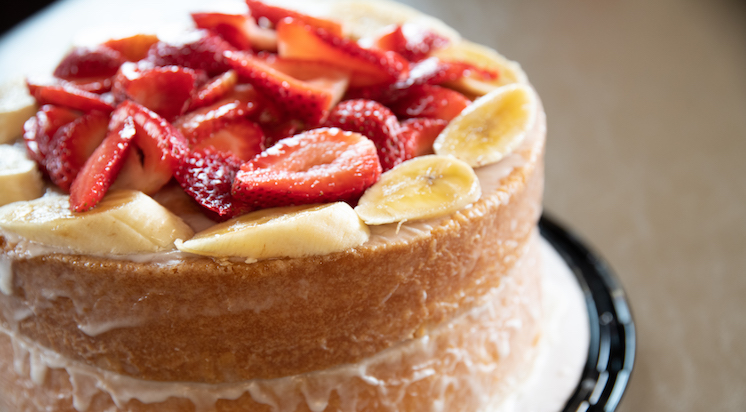 The strawberry and banana cake from Leo's BBQ, which features two layers of soft cake lined with sliced bananas on top and a pile of sliced strawberries.