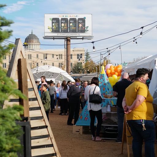 Numerous people visit art vendor tents in downtown OKC.