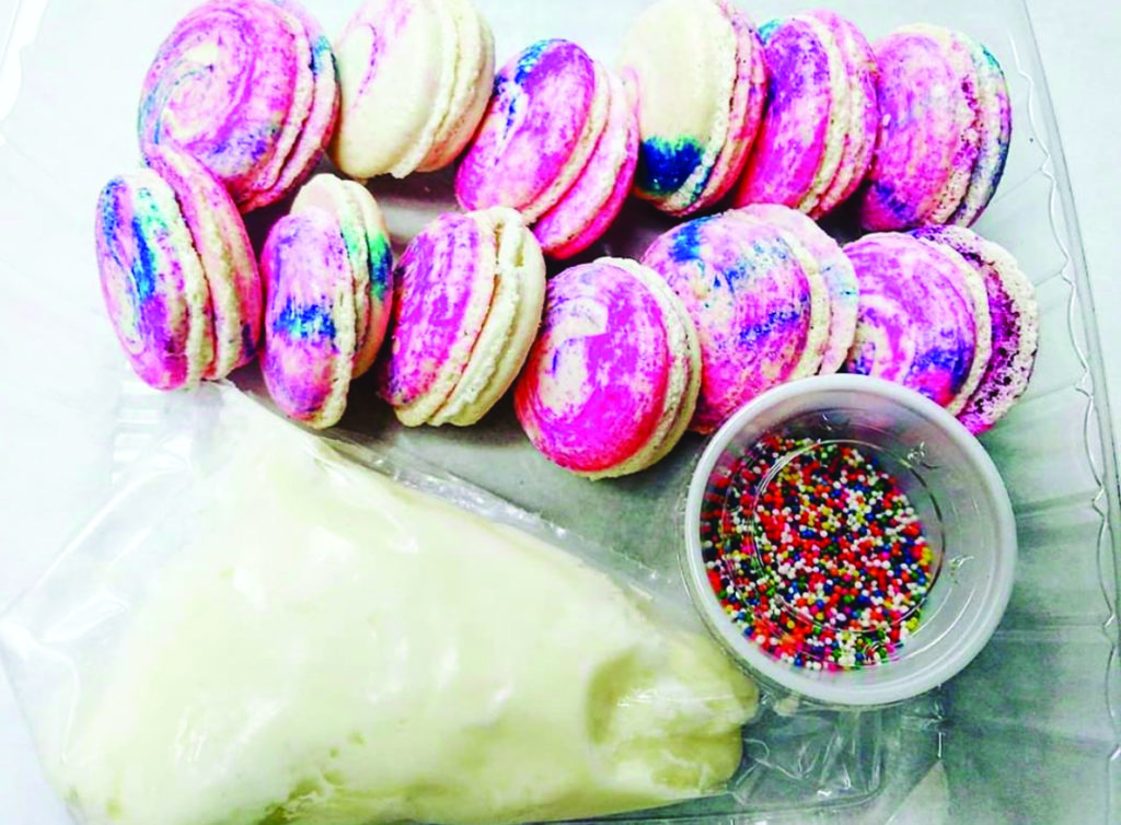 A macaron making kit with sprinkles and white frosting.