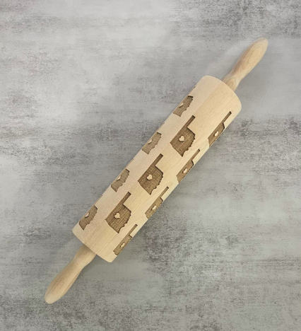A rolling pin that features the shape of Oklahoma with a star on Oklahoma City many times over.