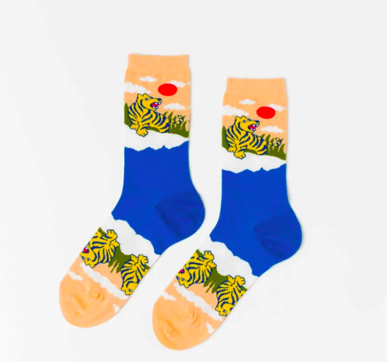 A pair of sock that depict the ocean and two tigers with a rising red sun.