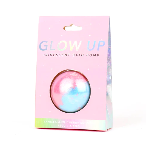 A light blue and pink bath bomb that reads "Glow Up" on the packaging.