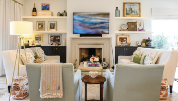 A cream-colored living room with two light-blue sofa chairs and an endtable between them.