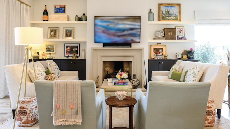 A cream-colored living room with two light-blue sofa chairs and an endtable between them.