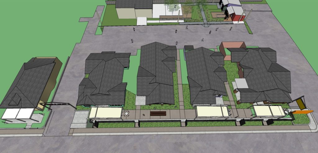 A bird's eye view of a complex with five bungalows and an outdoor stage north of them.