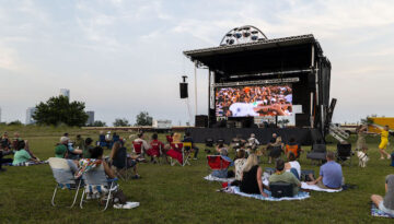 People sitting in lawn chairs and lying on blankets watch a film at Wheeler Park in Oklahoma City during deadCenter Film Festival.
