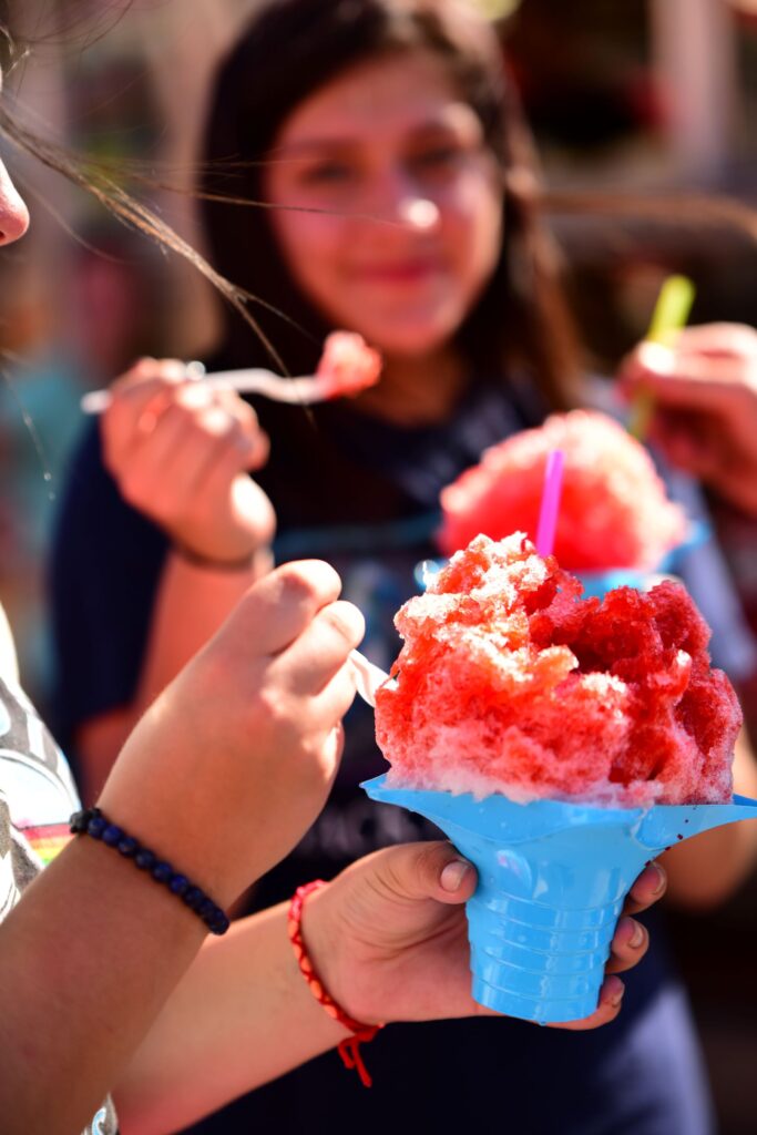 Fairgoers eating shaved ice at the Oklahoma State Fair.