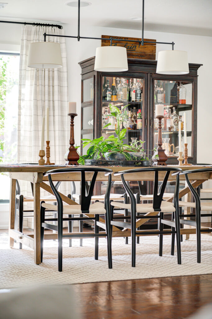 Edmond home kitchen table with black chairs in front of glass cabinet