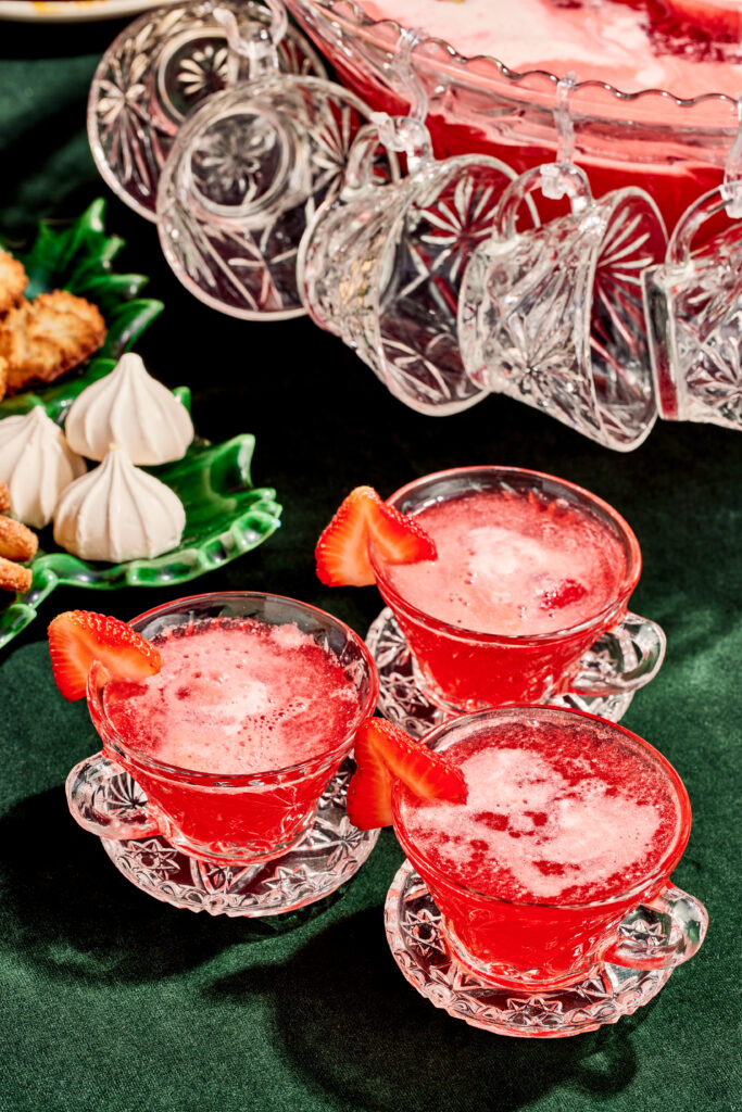 Rainbow sherbet punch in vintage punch glasses on a green velvet tablecloth