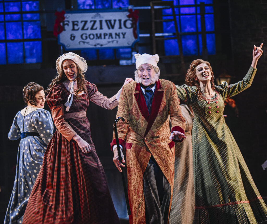 Two women and one man dancing in A Christmas Carol stage production