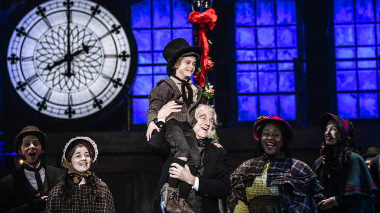 Man holding boy in A Christmas Carol stage production