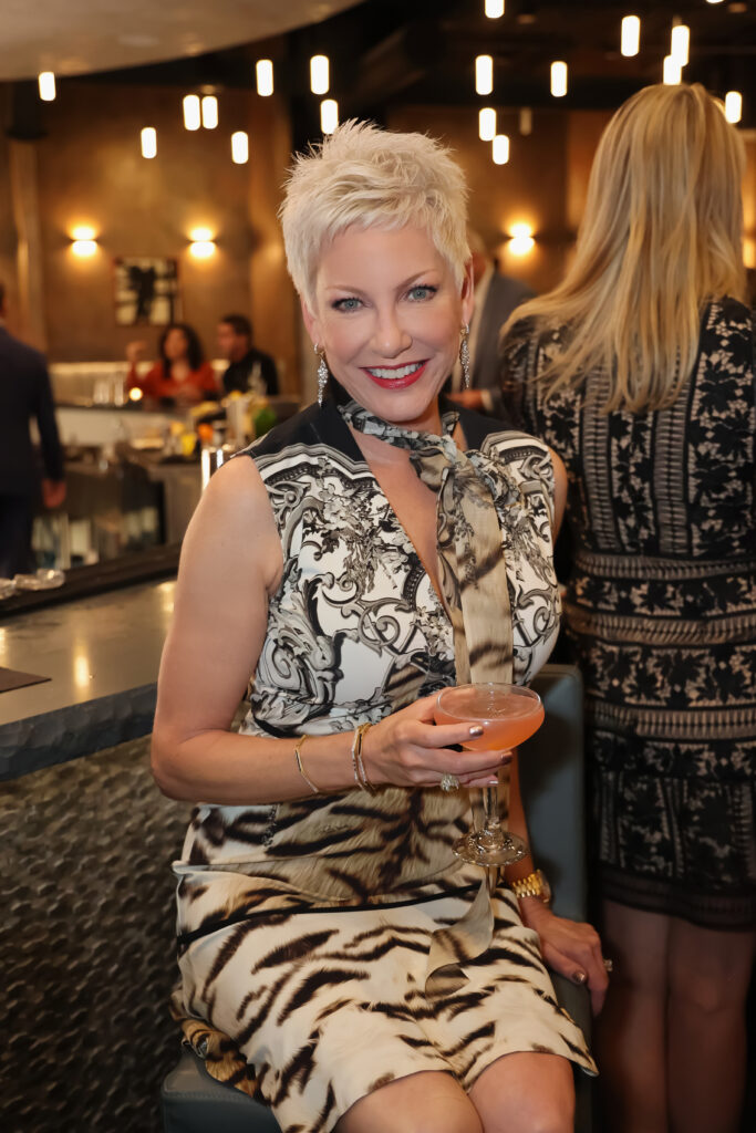 HER industry leader posing with a cocktail