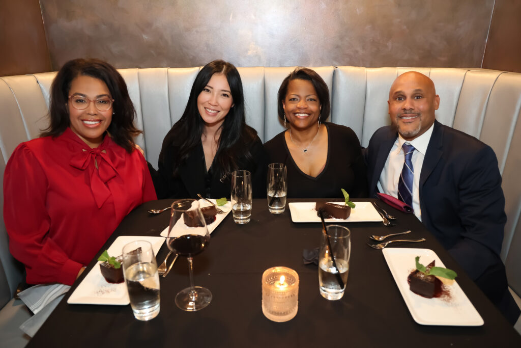 Four people sit at a table at Symmetry restaurant in OKC