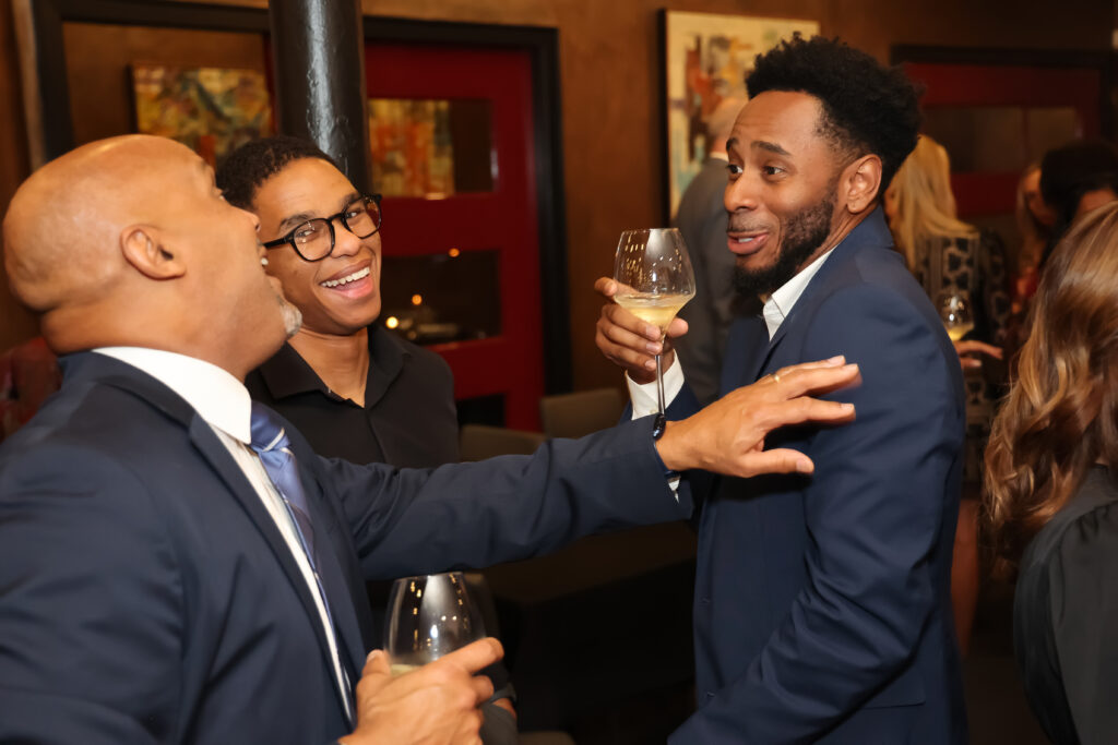 Three men talking at the HER awards celebration