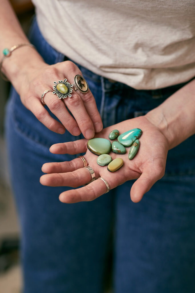Jewelry maker holding blue-green stones