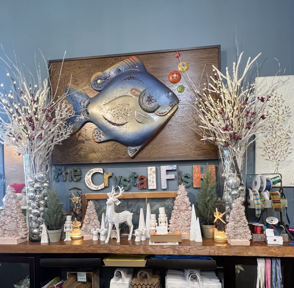 A wooden and metal sign from The Crystal Fish in Branson