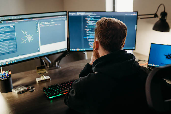 Andrew Lemon sitting down at the computer with his back facing away.