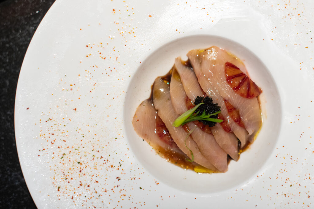 Bloody Hamachi Sashimi - yellowtail, blood orange, yuzu ponzu, black tobiko caviar, orange zest at Awaji Japanese Sushi Pub. Photograph by Rachel Maucieri.