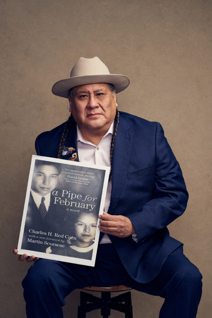 Yancey Red Corn shows off book cover written by his father, "A Pipe for February". Photo by Charlie Neuenschwander.